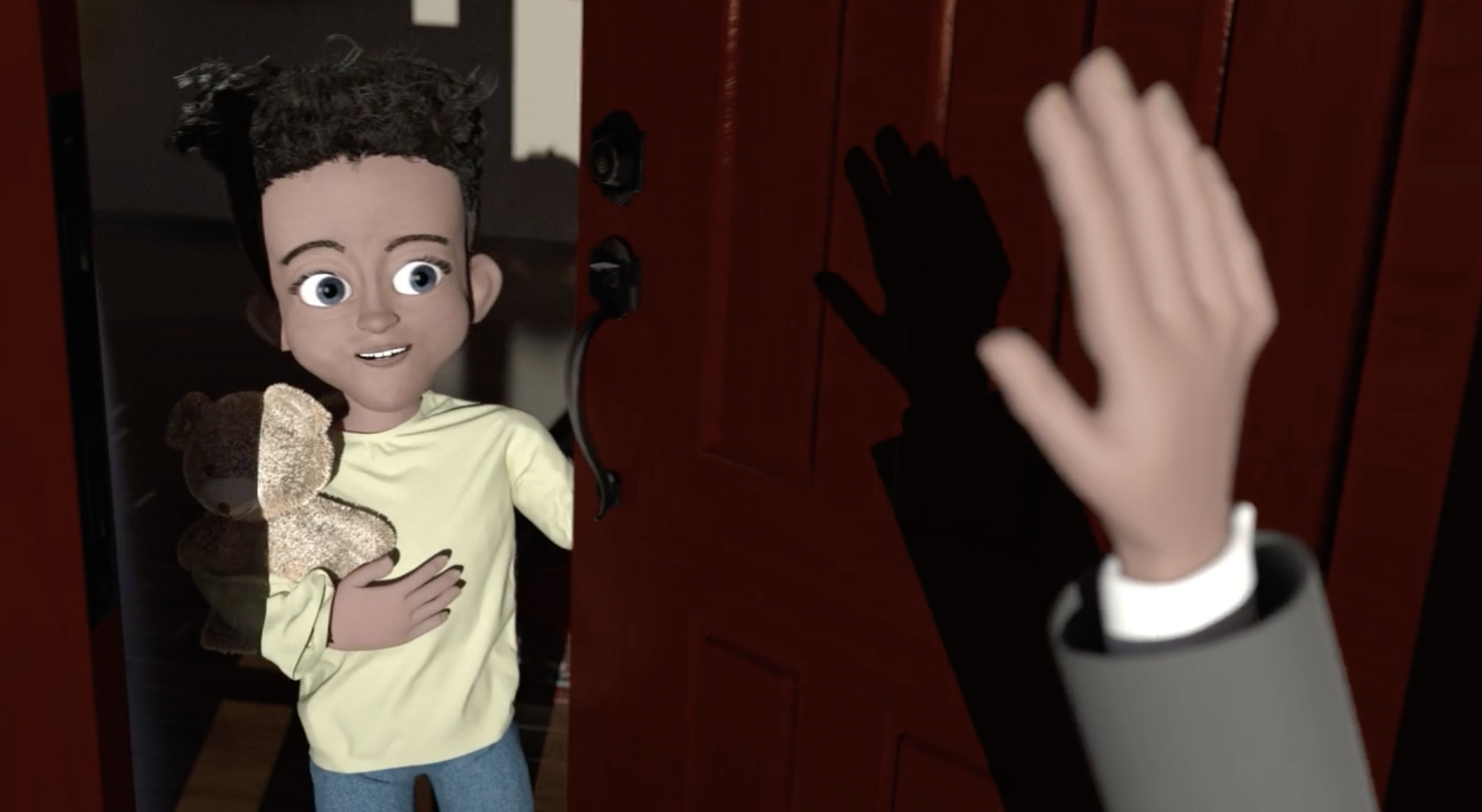 A little boy holding a teddy bear stands in a doorway looking up at someone's hand waving in a greeting